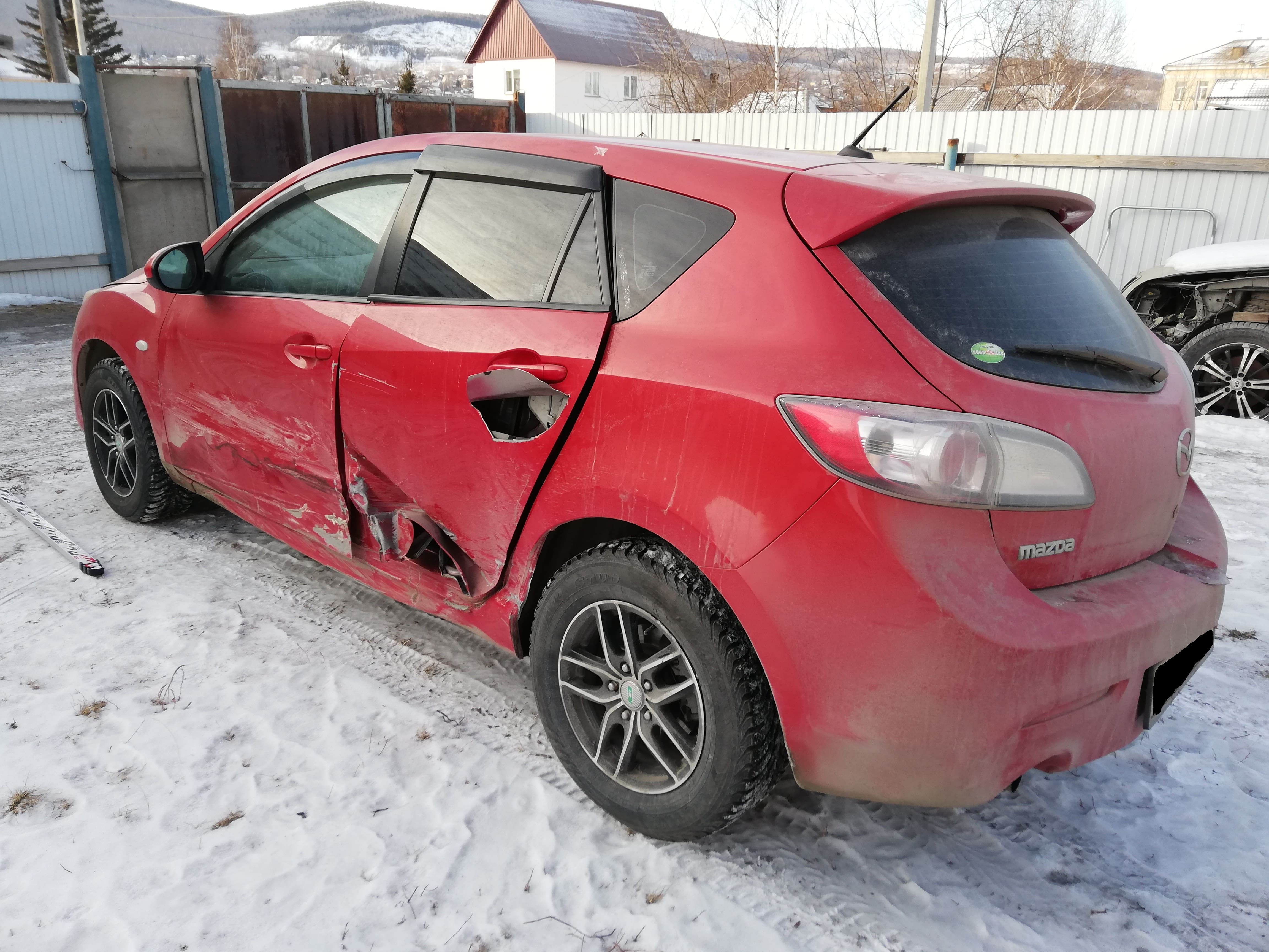Повреждения автомобиля Mazda Axella красного цвета в результате ДТП Автомобиль Mazda Axella красный